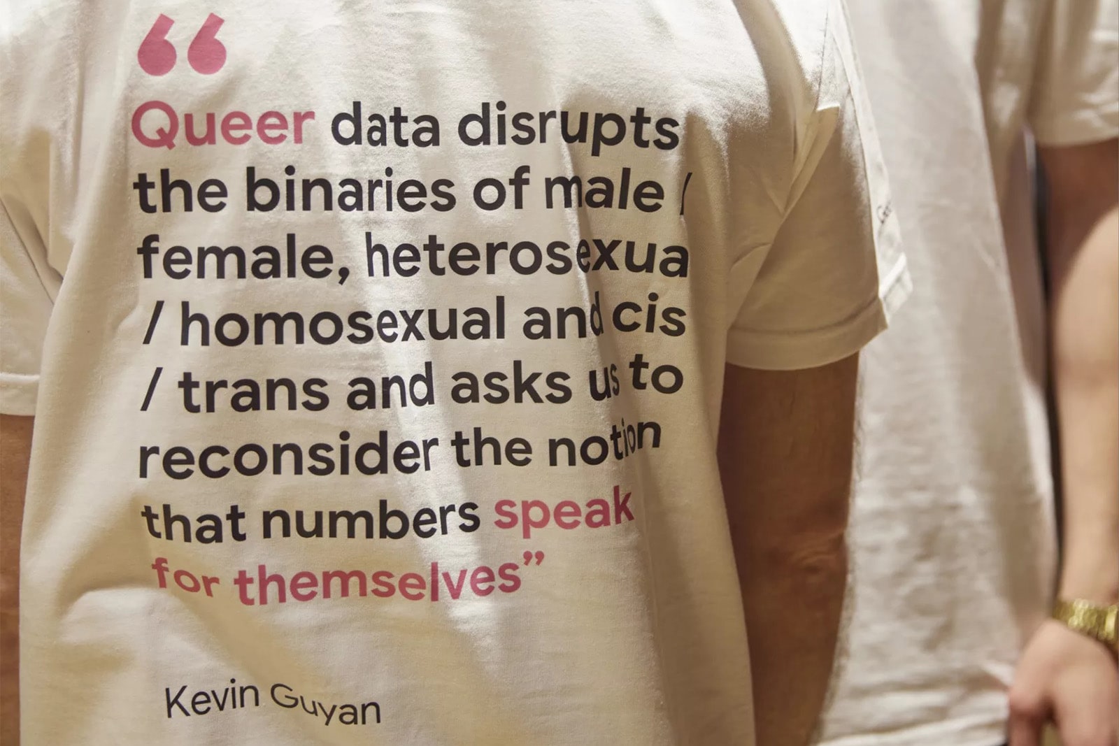 A quote by Kevin Guyan printed on the back of a t-shirt. The quote reads, 'Queer data disrupts the binaries of male/female, heterosexual/homosexual, and cis/trans and asks us to reconsider the notion that numbers speak for themselves'